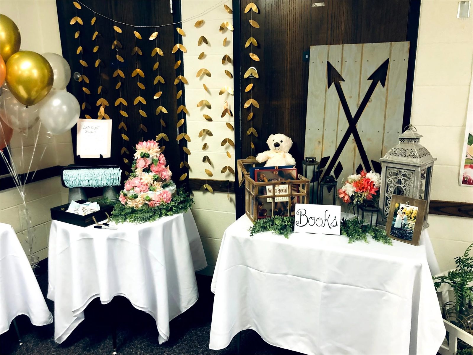 Baby shower gift and book table with gold leaf garlands, lanterns and a diaper cake